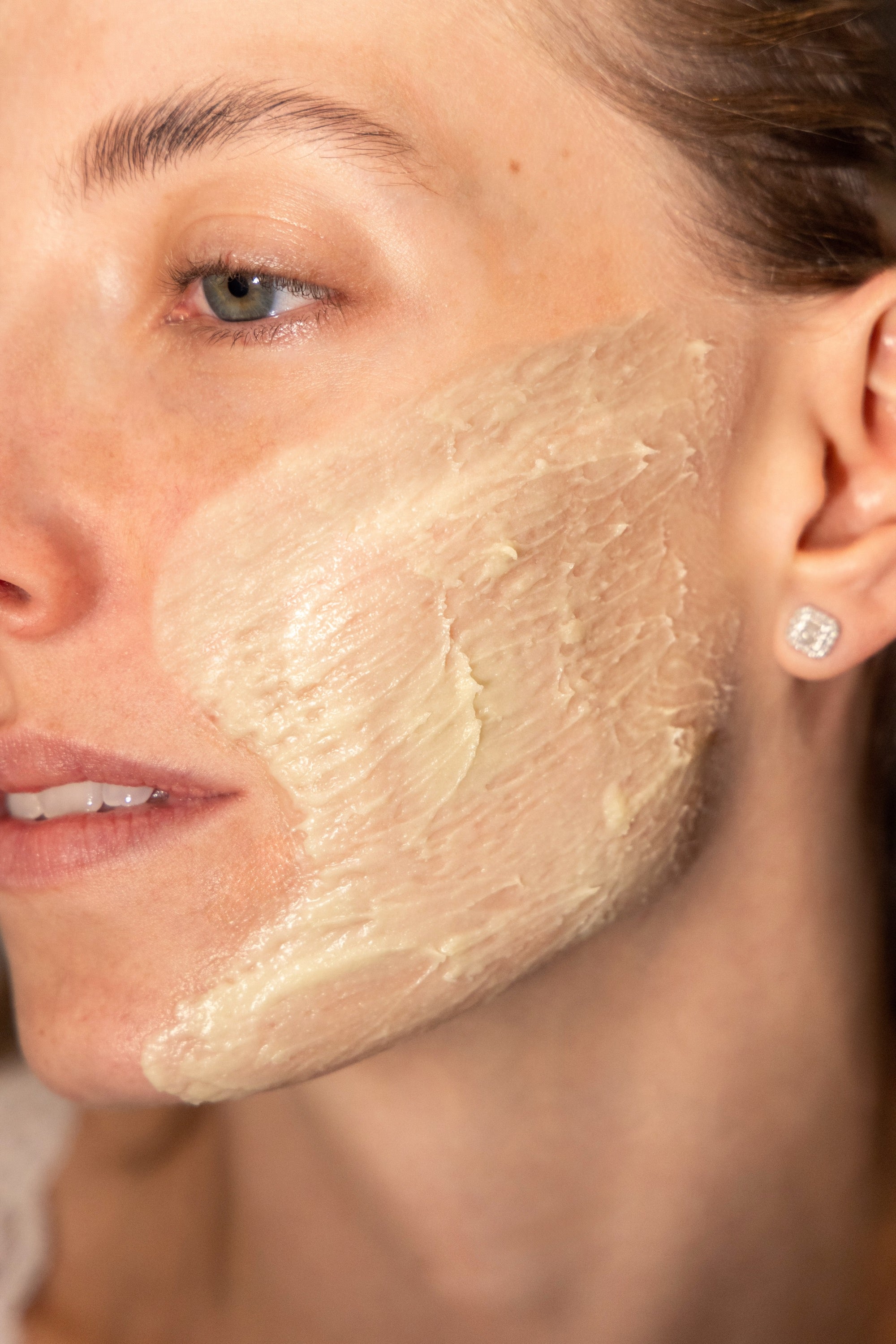 Detalle de piel del rostro con la crema aplicada, con brillo natural y luz lateral.